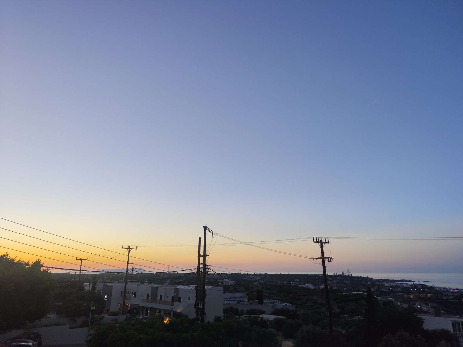 The sunset sky burning orange over the coast far below the terrace.