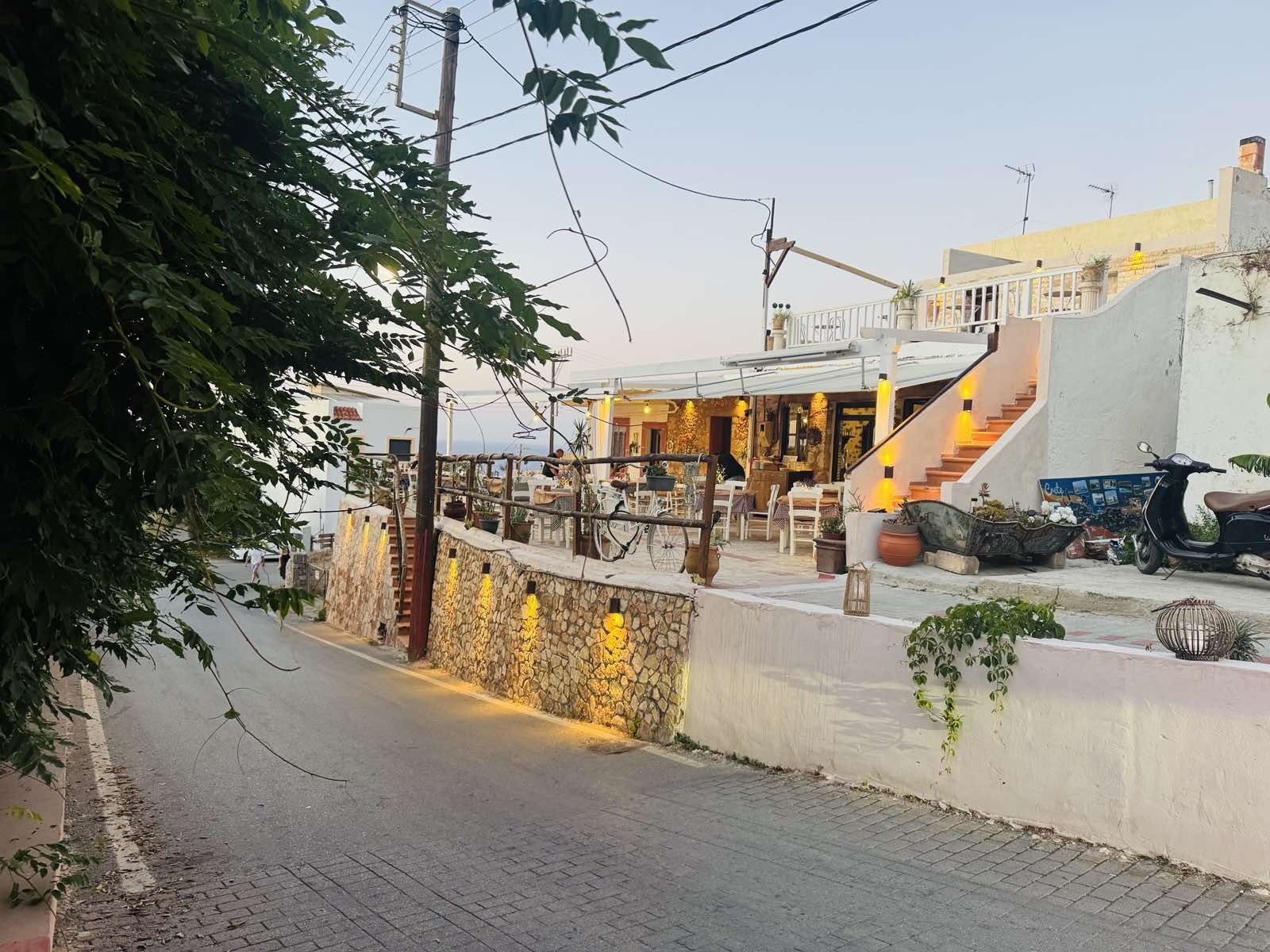 The narrow village lane climbing up towards the taverna.